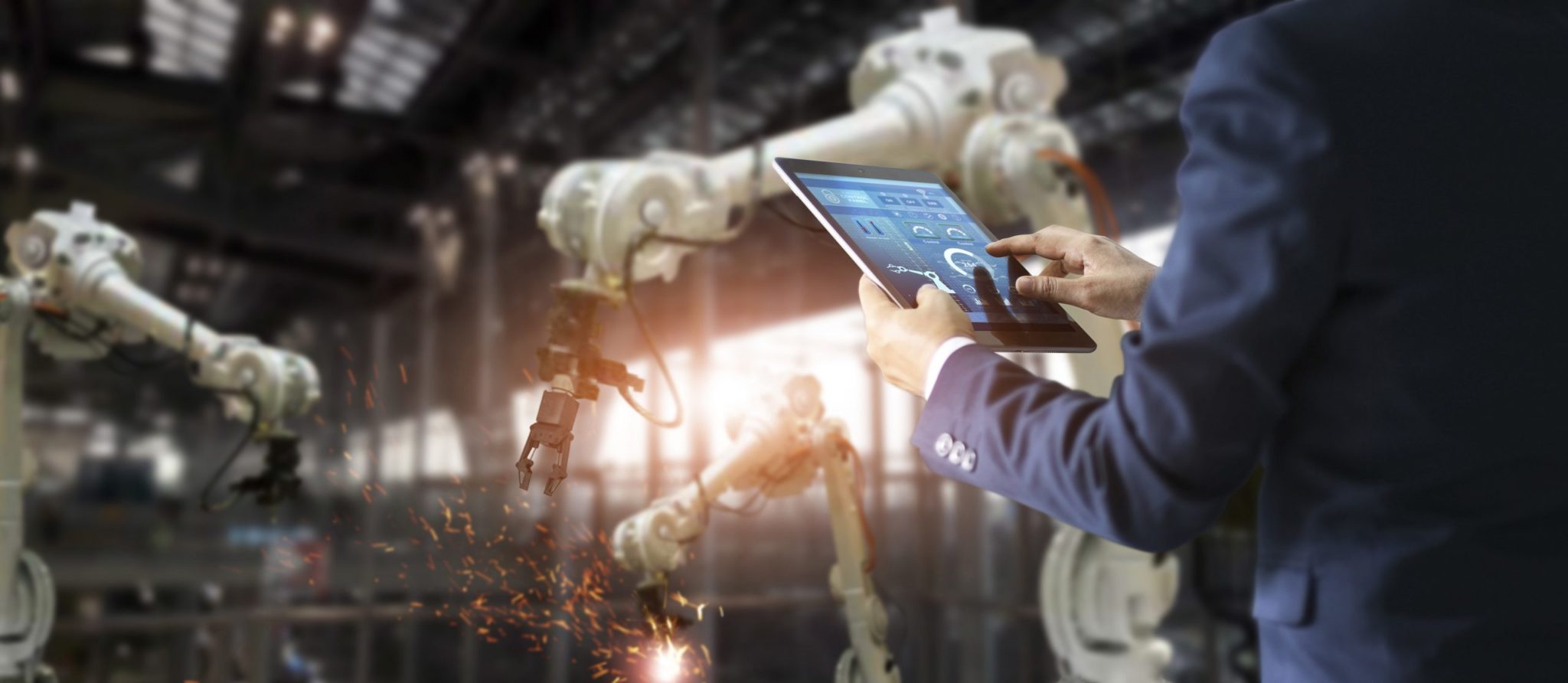 Industrial-engineer-manager-using-tablet-control-automation-robot-arms-machine-in-intelligent-on-monitoring -Welding-robotics-and-digital-manufacturing-operation -Industry-4 0-concept-scaled